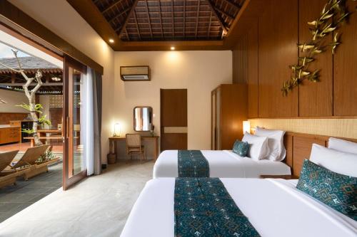 a hotel room with two beds and a living room at Sarva Ubud Villas & Spa in Ubud