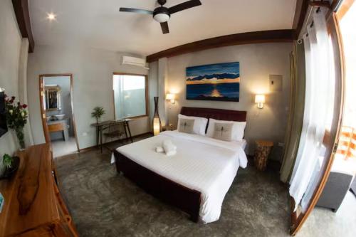 a bedroom with a large bed and a ceiling fan at Republika Beach Resort in San Juan