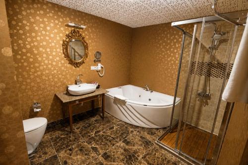 a bathroom with a tub and a sink and a shower at Sputnik Hotel Batumi in Batumi