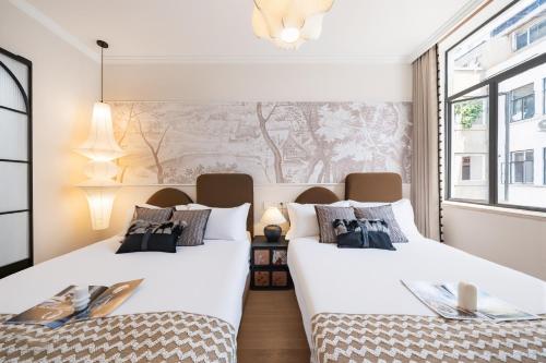 two beds in a room with a mural on the wall at Pine & Cedar Suites – Hua Xiao Ye in Shanghai