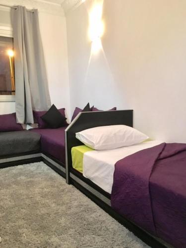 a bedroom with two beds and a couch at Appart Hotel Tanger Paname in Tangier