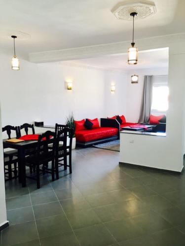 a living room with a red couch and a table at Appart Hotel Tanger Paname in Tangier