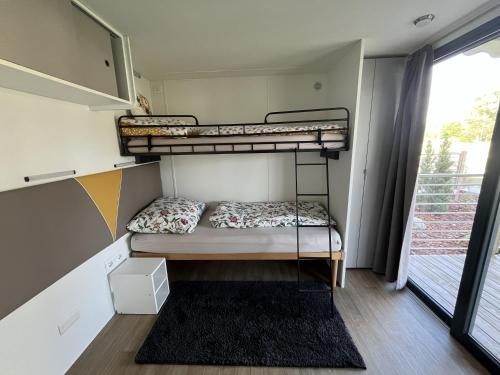 two bunk beds in a room with a window at Cseresznyés Házikók in Lipót