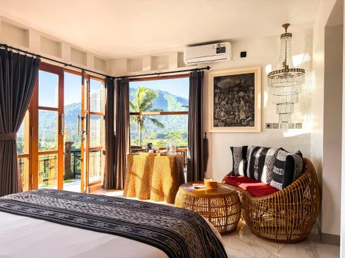a bedroom with a bed and chairs and a large window at Cempaka Guesthouse in Silebeng