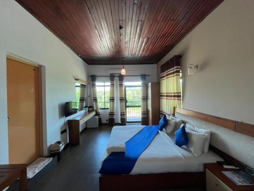 a bedroom with a large bed with blue pillows at Hotel Elephant Bay - World's Best Place to See the Elephants in Pinnawala