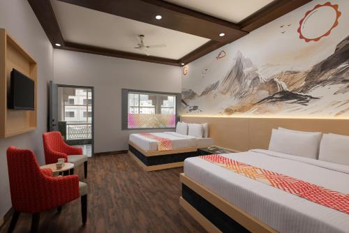 a hotel room with two beds and a tv at Ginger Katra in Katra