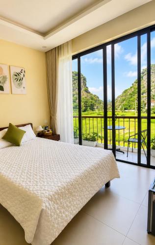 a bedroom with a bed and a large window at Tam Cốc AppA House in Ninh Binh