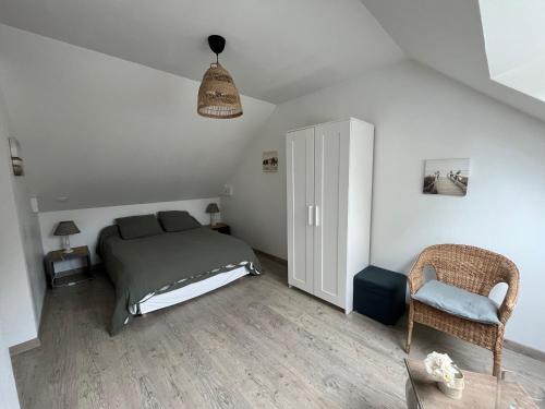 a bedroom with a bed and a chair at Les Chambres de Pascaline in Arrest