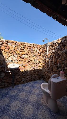 a stone bathroom with a toilet and a sink at Melody Surf Ekas Lombok in Ekas