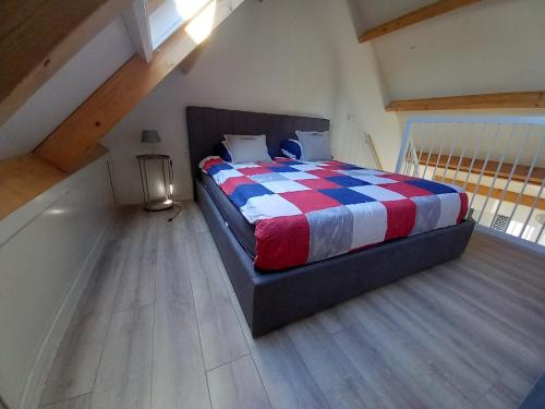 a bedroom with a bed with a red white and blue blanket at molenpad in Meliskerke