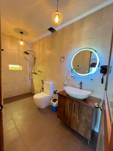a bathroom with a sink and a toilet and a mirror at Hotel Elephant Bay - World's Best Place to See the Elephants in Pinnawala