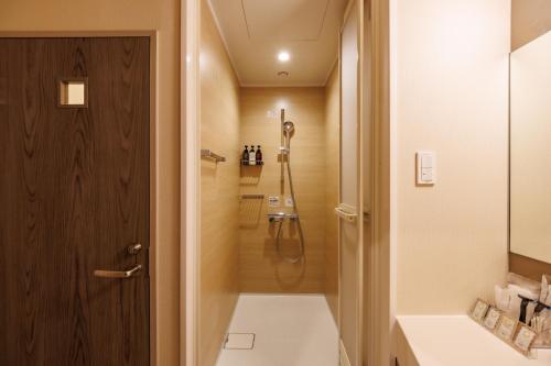 a bathroom with a shower and a toilet at ホテルグランリゾート蓼科 in Chino