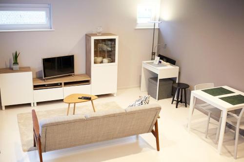 a living room with a couch and a tv and a table at B2B-flats AALST in Aalst