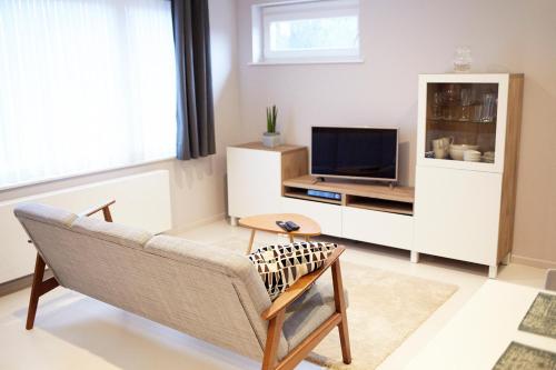 a living room with a couch and a tv at B2B-flats AALST in Aalst