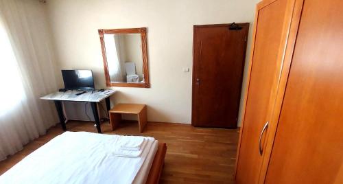 a bedroom with a bed and a desk and a mirror at Mesta Room in Gotse Delchev