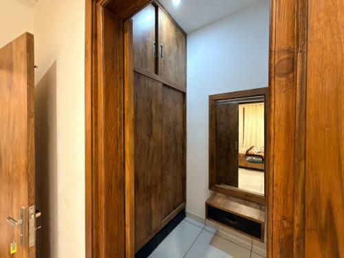a hallway with a wooden door and a window at Oak & Amber Retreat in Manāli