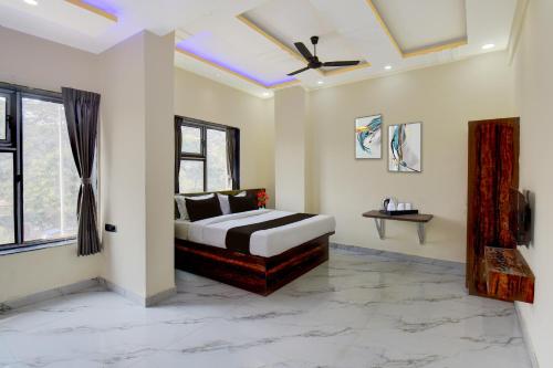 a bedroom with a bed and a ceiling fan at Super Collection O MIDC Pimpari Pune Formerly SK Palace in Chinchwad