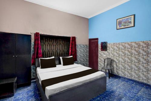 a bedroom with a bed and a chair in it at Hotel O Singar Nagar Metro Station Lucknow Formerly Highway Inn in Alambagh