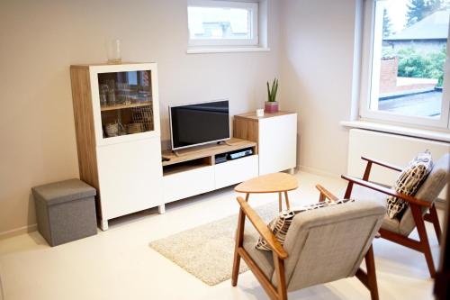 a living room with a tv and a chair at B2B-flats AALST in Aalst
