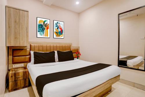 a bedroom with a large bed and a mirror at Collection O Crawford Market Formerly Al Ibrahim Hotel in Mumbai