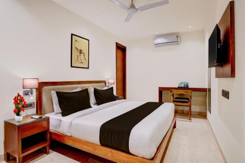 a bedroom with a large bed and a television at Townhouse Oak Sector 31 Noida in Noida