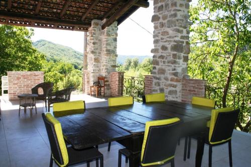 a wooden table and chairs on a patio with a view at Agriturismo Malvista in San Sebastiano Curone