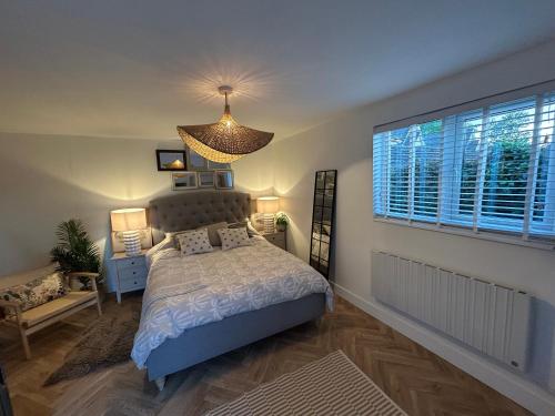 a bedroom with a bed and a large window at kingsize Little Home in Stamford