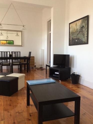 een woonkamer met een tafel en een tv bij Castle Apartment in Lissabon