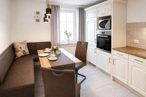 a kitchen and living room with a couch and a table at Panoramaferienwohnung Bergwiese in Masserberg