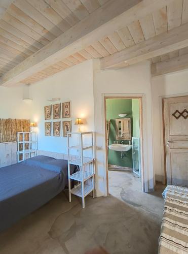 a bedroom with a bed and a bathroom with a sink at Casa Rosa in San Costanzo