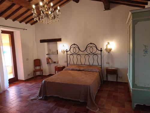 a bedroom with a bed and a chandelier at B&B La Camilla in Sipicciano