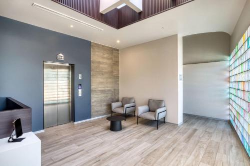 an office lobby with two chairs and a table at Comfort Suites Tijuana in Tijuana