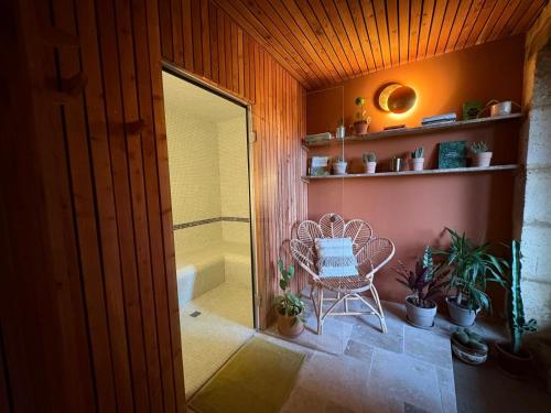 a bathroom with a chair and a shower with plants at Hôtel Particulier Nontron - chambre d'hôtes et meublés de tourisme in Nontron