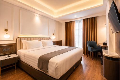 a hotel room with a bed and a desk at Arkadewi Boutique Hotel Prawirotaman in Yogyakarta