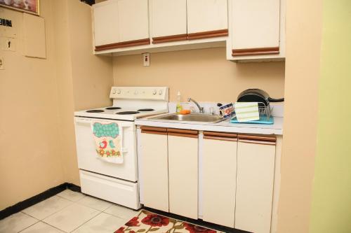 a kitchen with a white stove and a sink at Angel's Apartment Jamaica in Kingston
