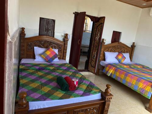 a bedroom with two beds and a backpack on the floor at Kabera Bungalow Ubud in Ubud
