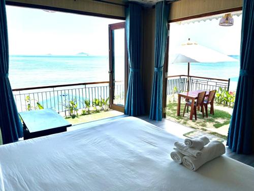 a bedroom with a bed and a view of the ocean at Hidden Beach Bungalow Sea View in Hoi An