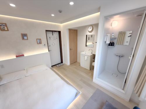 a white room with a shower and a toilet at RShotel in Tokyo