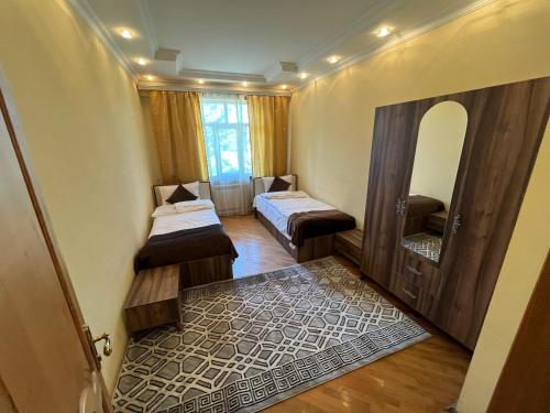 a room with two beds and a mirror at Rahat Hotel in Ganja