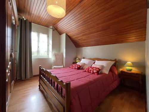 a bedroom with a large bed with a wooden ceiling at Chez lilles in Arette