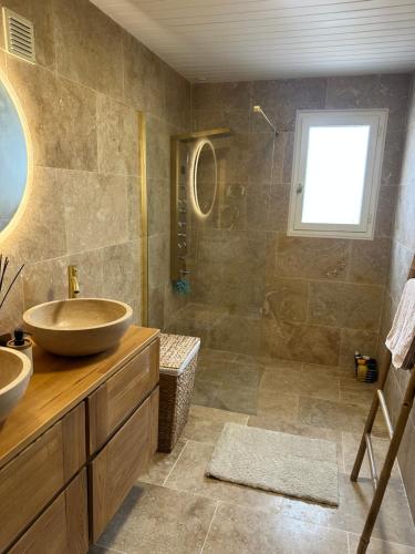 a bathroom with two sinks and a shower at La Villa cocooning in Changé