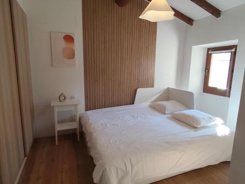 a bedroom with a white bed and a window at Bonlogem - Air-conditioned apartment Sainte Claire in Pertuis