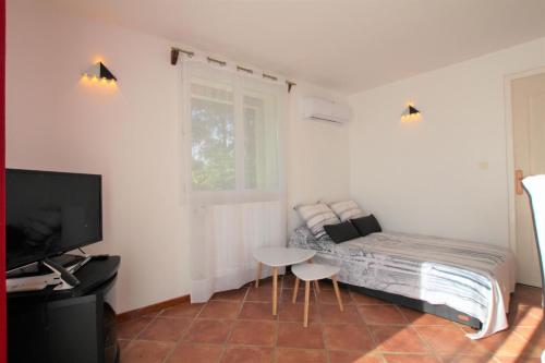 a bedroom with a bed and a table and a tv at Baserian in Saint-Pé-de-Léren