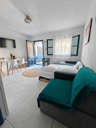 a bedroom with two beds and a table and chairs at Brilliance Sea View Apartments in Ouranoupoli