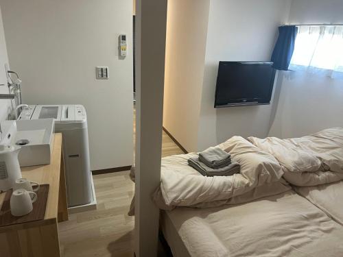 a room with a bed and a sink and a tv at ビジネスホテルinn in Kashima
