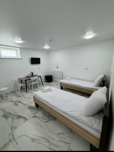 a room with two beds and a desk and a television at Ametist in Mukacheve