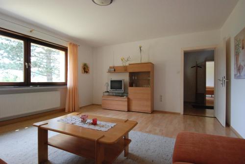 ein Wohnzimmer mit einem Couchtisch und einem TV in der Unterkunft Ferienwohnungen Fliegerstrasse in Gersfeld