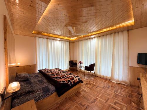 a bedroom with a large bed and a table with chairs at Oak & Amber Retreat in Manāli