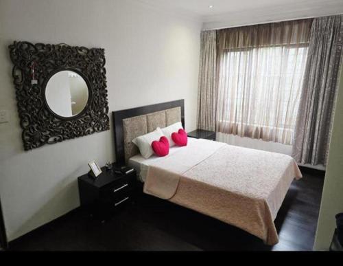 a bedroom with a bed with red pillows and a mirror at Fourways guesthouse & spa in Fourways