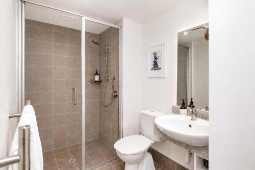 a bathroom with a shower and a toilet and a sink at Cathedral Junction Apartments in Christchurch